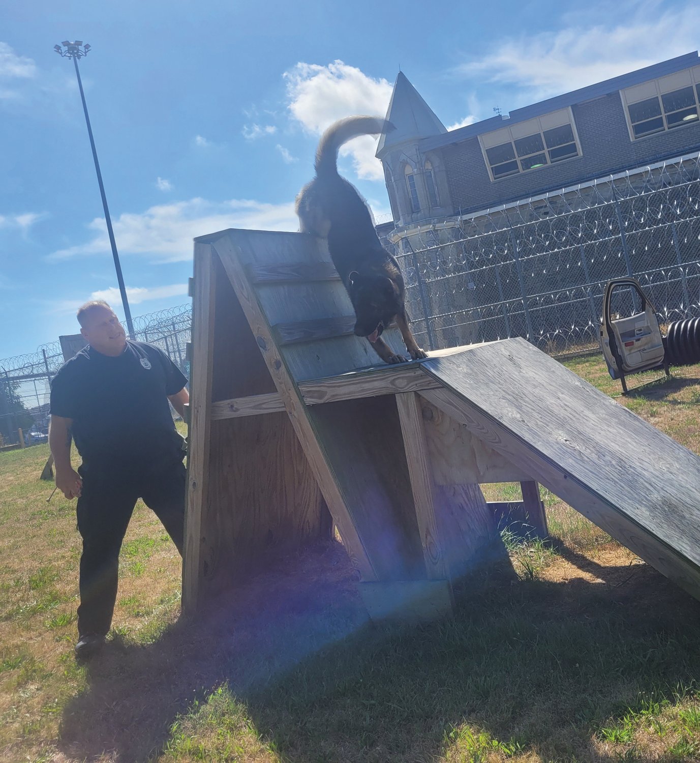 NO MOUNTAIN TOO HIGH: After a couple unsuccessful tries, K-9 Taz reaches the summit of a wooden obstacle on the police training course in the shadow of the maximum security prison in Cranston.